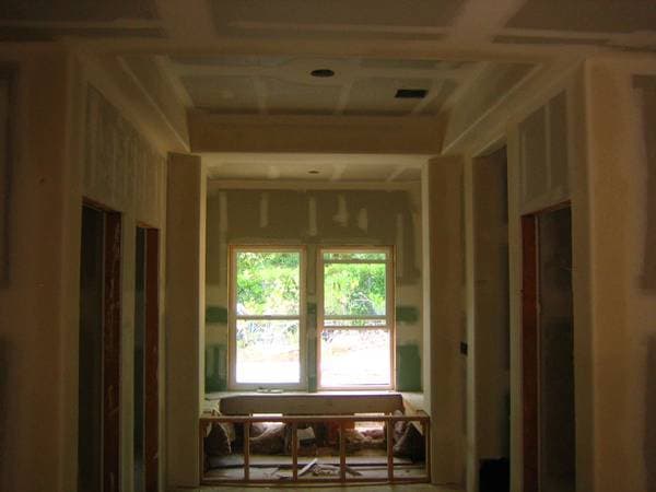 Drywall installation in progress with freshly hung sheets.