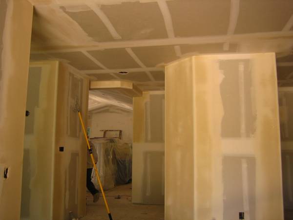 Drywall work around electrical boxes with precise cuts.
